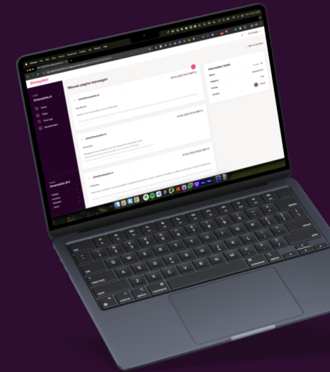 Laptop with website interface open, dark background, MacBook keyboard and various desktop icons visible.